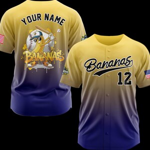 May include: Yellow and blue baseball jersey with the word "Bananas" in black script and the number 12. The jersey has an American flag patch on the sleeve. The back of the jersey features a cartoon banana playing baseball with the words "Your Name".
