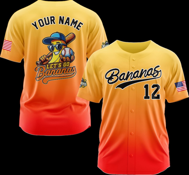 Puede incluir: Dos camisetas de b&eacute;isbol. Una es amarilla y naranja con "Your Name" en la espalda y un personaje de pl&aacute;tano con gafas de sol, un bate de b&eacute;isbol y una pelota de b&eacute;isbol. La otra camiseta es amarilla y naranja con "Bananas" y el n&uacute;mero "12".