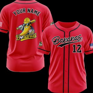 K&ouml;nnte beinhalten: Zwei rote Baseball-Trikots. Eines zeigt eine Bananenfigur mit Sonnenbrille und Baseballschl&auml;ger, den Text "Your Name" und "Bananas". Das andere Trikot hat "Bananas" und die Nummer "12" in Schwarz.