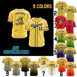 K&ouml;nnte beinhalten: Gelbes Baseball-Trikot mit schwarzen Akzenten, mit dem Text "Bananas 12" und einem Bananen-Charakter. Das Trikot hat eine Knopfleiste und wird mit anderen Farbvarianten gezeigt. Der Text "YOUR NAME" ist ebenfalls sichtbar.