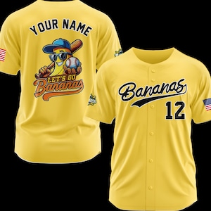 Puede incluir: Camiseta de b&eacute;isbol amarilla con la palabra "Bananas" en escritura negra y el n&uacute;mero 12. La camiseta tiene un parche de la bandera estadounidense en la manga. La parte posterior de la camisa tiene un pl&aacute;tano de dibujos animados con gafas de sol y una gorra de b&eacute;isbol, sosteniendo un bate y una pelota, con las palabras "Your Name" arriba y "Let's Go Bananas" abajo.