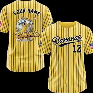 May include: Yellow baseball jersey with black pinstripes. The jersey features the word "Bananas" in script on the front, along with the number 12. The back has a cartoon banana character with a baseball bat and the text "Your Name".