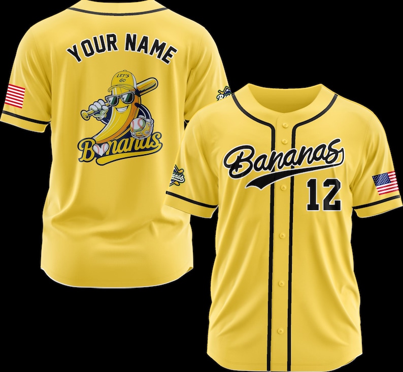 K&ouml;nnte beinhalten: Gelbes Baseball-Trikot mit schwarzem Besatz und dem Wort "Bananas" in Schreibschrift. Die Nummer 12 befindet sich auf der Vorderseite. Auf der R&uuml;ckseite befindet sich eine Bananenfigur mit Sonnenbrille und Baseballschl&auml;ger. Eine amerikanische Flagge befindet sich auf dem &Auml;rmel.