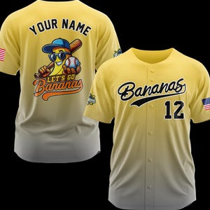 Puede incluir: Dos camisetas de b&eacute;isbol amarillas. Una presenta un pl&aacute;tano de dibujos animados con gafas de sol, un bate de b&eacute;isbol y una pelota de b&eacute;isbol. El texto "LET'S GO Bananas" est&aacute; debajo del pl&aacute;tano. La otra camiseta tiene "Bananas" en escritura y el n&uacute;mero "12". Ambas tienen una bandera estadounidense.