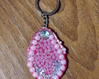 Chaveiro de resina em formato de vulva com glitter rosa