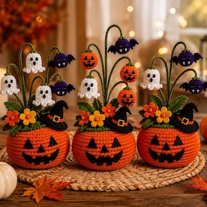 May include: Three crocheted Halloween decorations featuring orange pumpkin bases with black jack-o'-lantern faces. Each arrangement includes green stems topped with small crocheted ghosts, purple bats, orange pumpkins, and black witch hats with yellow buckles.