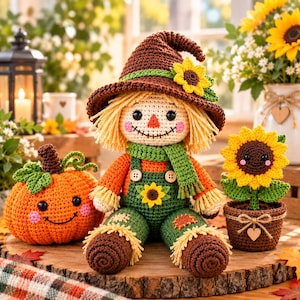 Könnte beinhalten: Eine gehäkelte Vogelscheuchen-Puppe mit braunem Hut und Sonnenblume, orangefarbenem Hemd und grüner Latzhose mit Sonnenblumen-Aufnäher. Daneben stehen ein gehäkelter, lächelnder orangefarbener Kürbis und eine lächelnde Sonnenblume im Topf.