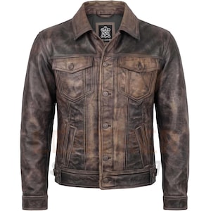 May include: A dark brown leather jacket with a distressed finish, featuring a pointed collar, a front button closure, two chest pockets with buttoned flaps, and two vertical side pockets. The jacket has long sleeves with buttoned cuffs.