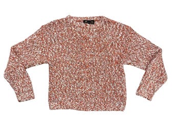 May include: A long-sleeved sweater in a speckled pattern of red, white, and brown. The knitwear features a crew neck and a textured design. The sleeves are long and the sweater is a standard length. The garment is made of a soft, comfortable material.
