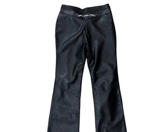 May include: Black leather pants with a flared leg design. The pants have a decorative silver-colored embellishment at the waist. The pants are made of a smooth, shiny material.