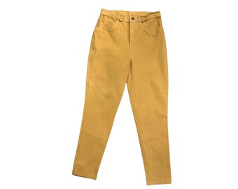 May include: Mustard-colored denim pants with a high waist and straight leg. The pants have a button and zipper closure, with decorative stitching near the front pockets. The pants are made of a sturdy denim material.