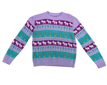 May include: A lilac-colored sweater with a crew neck and long sleeves. The sweater features a repeating pattern of white goats, green trees, and teal and purple stripes. The cuffs and hem are solid lilac.