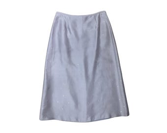 May include: A knee-length lavender skirt with a smooth, slightly lustrous finish. The garment features a subtle, scattered pattern of tiny, reflective silver-toned dots across the entire surface, a fitted waistband, and a straight, clean-cut hemline.