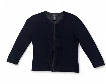 May include: A navy blue zip-up cardigan with long sleeves. The cardigan features a beaded design along the zipper and neckline. The brand tag is visible at the neckline. The garment is displayed on a white background.