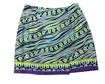 May include: A colorful wrap skirt with a vibrant, wavy pattern in shades of black, purple, yellow, and teal. The skirt features a floral and teardrop border design. The skirt is secured with a button closure.