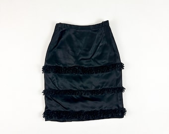 May include: A black satin skirt with multiple layers of black lace trim.