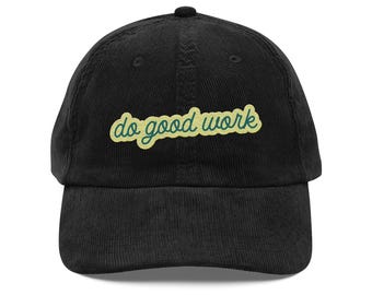 May include: Black corduroy baseball cap with a curved brim. The cap features the embroidered text "do good work" in a cursive font with a yellow-green outline.