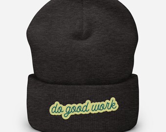 May include: Dark gray beanie with the embroidered text "do good work" in a light green script. The beanie is a knit cap, suitable for cold weather. The hat is a simple, yet stylish accessory.
