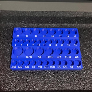 May include: A blue tool organizer with multiple circular openings of varying sizes, labeled with fractional and numerical measurements. The organizer is designed to hold tools and parts, with sizes ranging from 5/32 to 24.