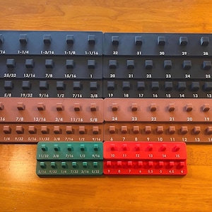 Könnte beinhalten: Eine weiße Keramik-Tasse mit schwarzem Henkel und dem Text "But First, Coffee" in schwarzer, handschriftlicher Schrift. Die Tasse steht auf einer weißen Oberfläche.