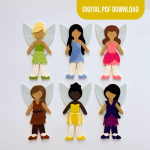May include: Six felt fairy cutouts arranged in two rows. Each figure features light gray wings and distinct hair colors including blonde, black, brown, and dark brown, paired with colorful dresses in green, blue, pink, brown, yellow, and purple.