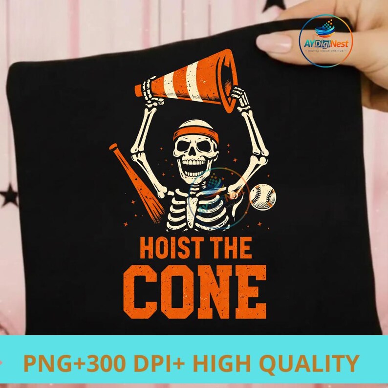 May include: Black t-shirt featuring a skeleton holding an orange and white traffic cone, with a baseball and bat. The text "HOIST THE CONE" is in orange. A fun, Halloween-themed design.