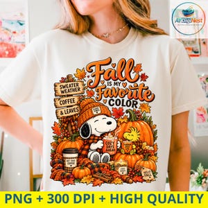 May include: A cream-coloured t-shirt featuring a graphic of Snoopy wearing a beanie and holding a mug labelled COZY DAYS AHEAD. The design includes pumpkins, autumn leaves, and wooden signs reading SWEATER WEATHER and COFFEE & LEAVES.