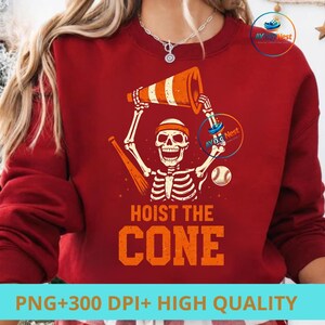 May include: Red sweatshirt with a graphic of a skeleton holding an orange and white traffic cone, a baseball bat, and a baseball. The text "HOIST THE CONE" is below the skeleton. The bottom of the image has the text "PNG+300 DPI+ HIGH QUALITY".