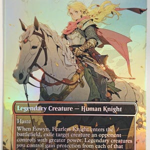 May include: A holographic trading card titled Eowyn, Fearless Knight, featuring an illustration of a blonde knight in armor riding a white horse. The card text includes Legendary Creature - Human Knight, Haste, and game rules. The card is marked R 0201 LTR EN.