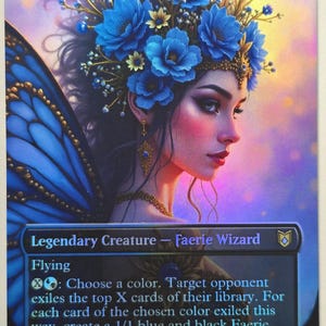 May include: A Magic: The Gathering card featuring Oona, Queen of the Fae. The card depicts a woman with blue floral headwear and wings. Text includes "Legendary Creature - Faerie Wizard" and "Flying". The card has a 5/5 power and toughness.