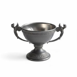 Peut inclure: Un calice de couleur étain avec une base en piédestal et deux poignées ornées. Le bol a une bande décorative autour du bord. Les poignées ont la forme d'oiseaux stylisés. Le calice est probablement utilisé à des fins décoratives.
