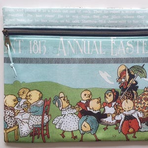 Może przedstawiać: Prostokątna kosmetyczka zapinana na zamek z fantazyjną ilustracją. Projekt przedstawia jasnoniebieskie tło z tekstem "NT 1813 ANNUAL EASTER PA". Ilustracja przedstawia antropomorficzne pisklęta i koguta w sielankowej scenerii.