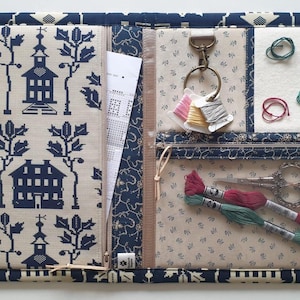 The Old Schoolhouse stitching companion for notions. 2 zipped pockets, floss-drop clip, thread bed. 18"x12" open.