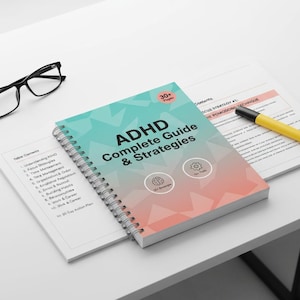 Może przedstawiać: Książka w oprawie spiralnej zatytułowana "ADHD Complete Guide & Strategies" z turkusowo-koralową okładką, obok pary czarnych okularów i żółtego zakreślacza. Książka leży na białej powierzchni.