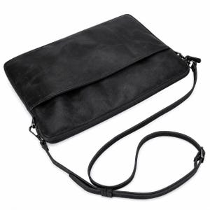 May include: A rectangular black shoulder bag with a smooth, matte finish. The bag features a zippered main compartment, a front flap pocket, and a thin, adjustable black shoulder strap attached with dark metal hardware on both sides.