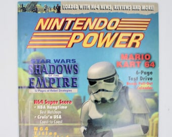 Puede incluir: Una portada de revista para Nintendo Power, con una portada del juego Star Wars: Shadows of the Empire y una portada del juego Mario Kart 64. La revista también incluye una prueba de manejo de 6 páginas de Mario Kart 64 y un calendario extraíble de bonificación.