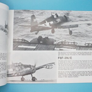 May include: A black and white photograph of a Grumman F6F-3N Hellcat fighter plane taking off from an aircraft carrier. The plane has the number 319 painted on the side. The photo is from World War II.