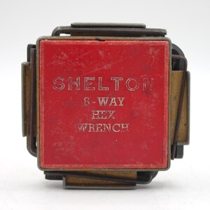 May include: A red metal box with the text "SHELTON 8-WAY HEX WRENCH" printed on it.