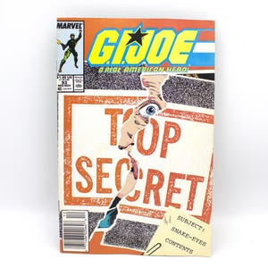 May include: A vintage G.I. Joe comic book with a torn cover revealing a face and the words "TOP SECRET." The comic features the Marvel logo, issue number 93, and the text "A REAL AMERICAN HERO!" in bold letters. The cover is primarily orange, blue, and yellow.