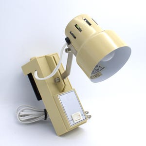 May include: A white ceramic mug with a black handle and the text "But First, Coffee" in a bold, black font. The mug is set against a blurred background, highlighting its clean design.