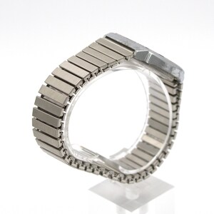 Peut inclure: Une montre-bracelet argent&eacute;e avec un cadran rectangulaire et un bracelet en m&eacute;tal flexible. Le bracelet est compos&eacute; de nombreux petits maillons rectangulaires. La montre est pr&eacute;sent&eacute;e sur un support transparent sur fond blanc.