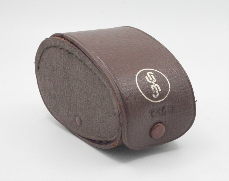 May include: A brown leather case with a white circle containing the letters "GSS" and the word "Prat" printed on it.