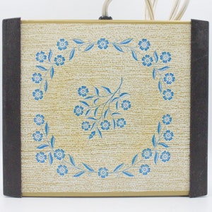 May include: A vintage electric warming tray with a brown trim and a beige surface with a blue floral design.