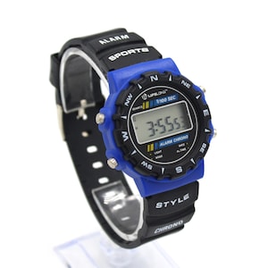 May include: A digital sports watch with a black band and a blue bezel. The watch face displays the time and has the text "LIFELONG", "ALARM", "SPORTS", and "STYLE". The watch is displayed on a white background.