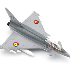 May include: A gray and white model airplane with red, white, and blue markings. The airplane has a clear cockpit and is sitting on a white background.