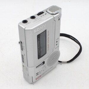 May include: A silver Sony Clear Voice Plus voice recorder with a black strap. The recorder has a small LCD screen, a microphone, and a speaker. The text "VOR" and "AUTO REVERSE" are visible on the recorder.