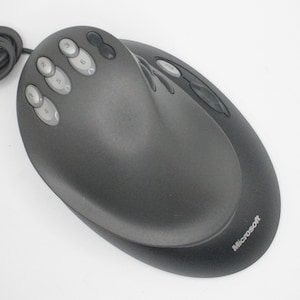 May include: A black Microsoft ergonomic mouse with multiple buttons on the top and a scroll wheel on the side.