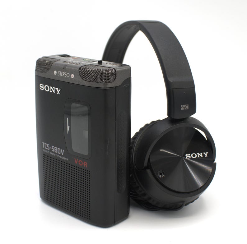 May include: A black Sony TCS-580V cassette recorder with a matching black over-ear headphone set. The recorder has the Sony logo and the word "STEREO" printed on it. The headphones are also branded with the Sony logo.
