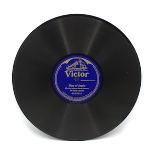 May include: A vintage black vinyl record with a blue and white label. The label reads "Victor" and features the title "Mary of Argyle" by Sir Harry Lauder. The record is a 78 RPM, a classic piece of music history.