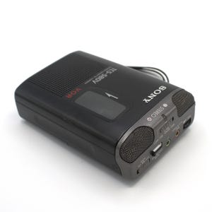 May include: Black Sony TCS-580V cassette recorder with a dark gray speaker grill and the word "SONY" in white. The recorder has a VOR function and a stereo output. The model number is visible on the top.